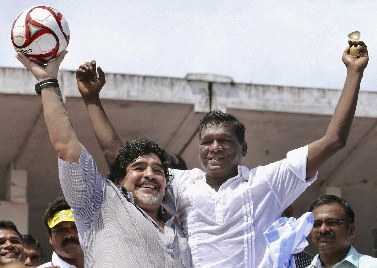 In this Wednesday, Oct. 24, 2012 photo, Argentina soccer legend Diego Maradona, left, and Indian football player I.M.Vijayan acknowledge the crowd, unseen, in Kannur, Kerala, India. Maradona enthralle ...
