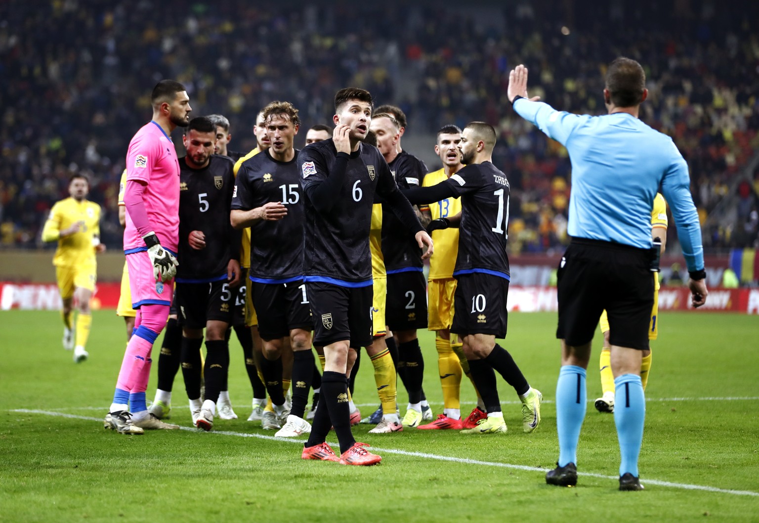 epa11723613 Players of Kosovo (in black) gather to leave the pitch after a group of supporters chanted pro Serbia chants before the end of the UEFA Nations League soccer match between Romania and Koso ...