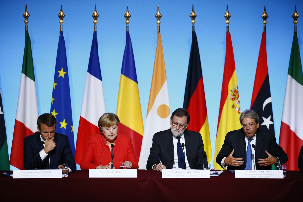 Italian Premier Paolo Gentiloni, right, gestures as he addresses the media during a joint press conference with German Chancellor Angela Merkel, 2nd left, France's President Emmanuel Macron, left ...