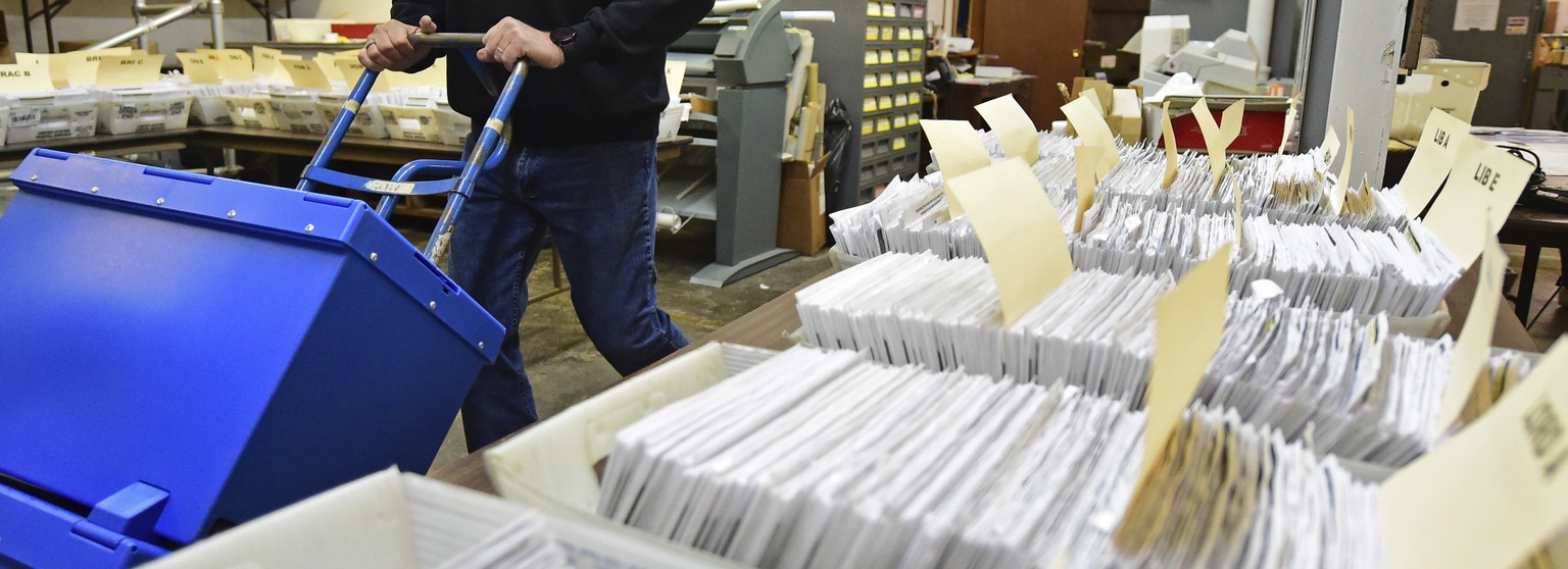 Board of Elections worker Bob Moody moves boxes of ballots at the Trumbull County Board of Elections, Tuesday, Nov. 3, 2020, in Warren, Ohio. (AP Photo/David Dermer)