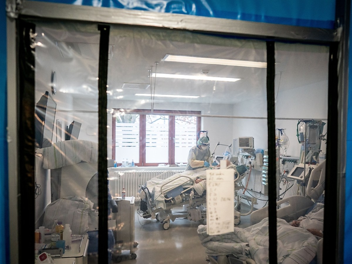 ARCHIV - Ein Intensivpfleger betreut hinter einer Schleuse auf der Intensivstation des Krankenhauses Bethel in Berlin einen Corona-Patienten. Foto: Kay Nietfeld/dpa