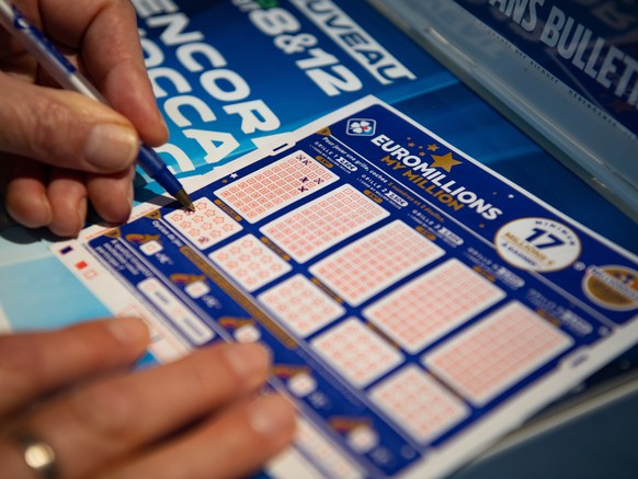 epa08862326 A person plays a EuroMillions grid in Bordeaux, France, 04 December 2020. The jackpot for this draw will reach 200 million euro. Before 2020, the jackpot was capped at 190 million euros. E ...