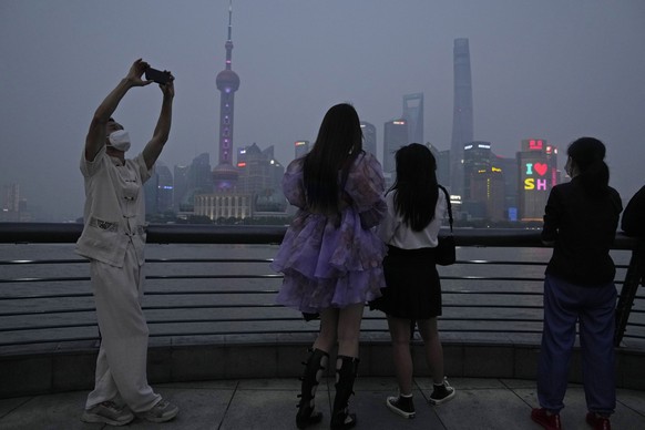Residents enjoy the view at dusk along the bund, Wednesday, June 1, 2022, in Shanghai. Traffic, pedestrians and joggers reappeared on the streets of Shanghai on Wednesday as China's largest city began ...