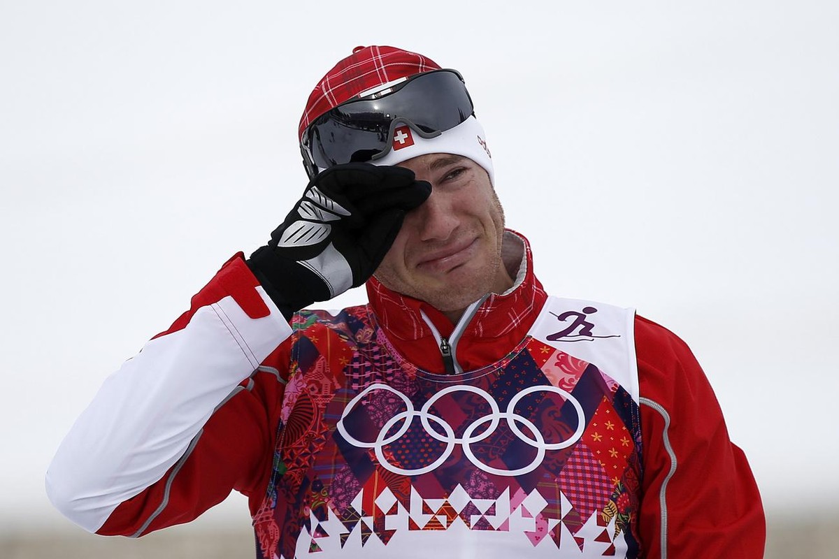Switzerland's Dario Cologna reacts on the podium of the flower ceremony after winning the men's cross country skiing skiathlon at the XXII Winter Olympics 2014 Sochi at the Laura cross count ...
