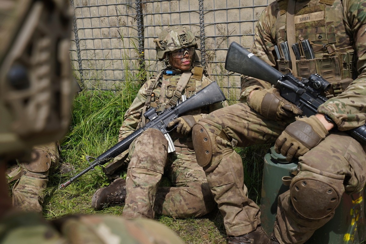A female conscript sits with members of her unit during final exercises at a training area close to Royal Danish Army's barracks in Hovelte, 25 kilometres north of Copenhagen, Denmark, Wednesday, ...
