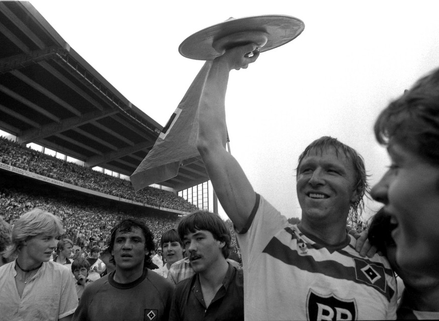 Hamburger Sport-Verein captain Horst Hrubesch holds up the Champions Trophy as Hamburg SV won the German Soccer Bundesliga after they defeated FC Schalke 04 2-1 in their last match of the season in Ge ...