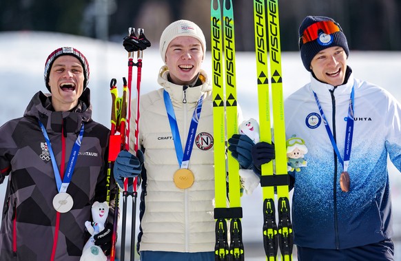 Silver medalist Johannes Lamparter, of Austria, from left, gold medalist Jens Luraas Oftebro, of Norway, and bronze medalist Eero Hirvonen, of Finland, pose on the podium of the Nordic Combined Indivi ...
