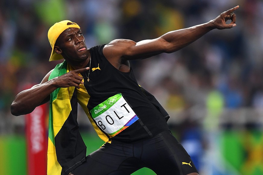 epa05485979 Usain Bolt of Jamaica celebrates after placing first and the gold medal in the men's 100m final race of the Rio 2016 Olympic Games Athletics, Track and Field events at the Olympic Stadium  ...