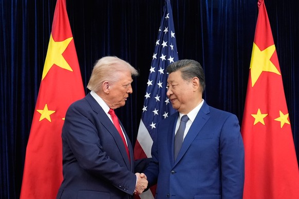 President Donald Trump, left, and Chinese President Xi Jinping, right, shake hands before their meeting at Gimhae International Airport in Busan, South Korea, Thursday, Oct. 30, 2025. (AP Photo/Mark S ...