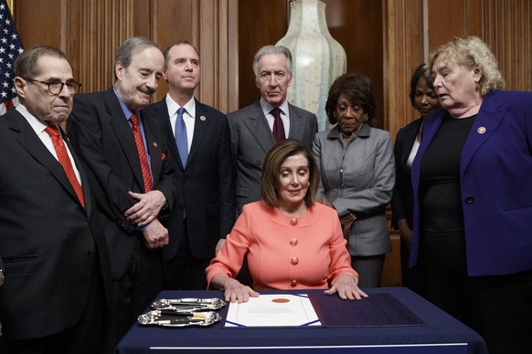 epa08131953 Speaker of the House Nancy Pelosi, with committee chairs and House impeachment managers, signs the articles of impeachment during an engrossment ceremony prior to them being walked across  ...