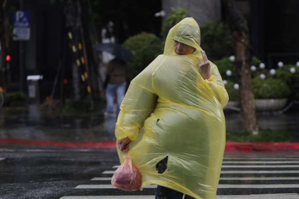 A woman struggles with wind and rain generated by Typhoon Kong-rey in Taipei, Taiwan, Thursday, Oct. 31, 2024. (AP Photo/Chiang Ying-ying)