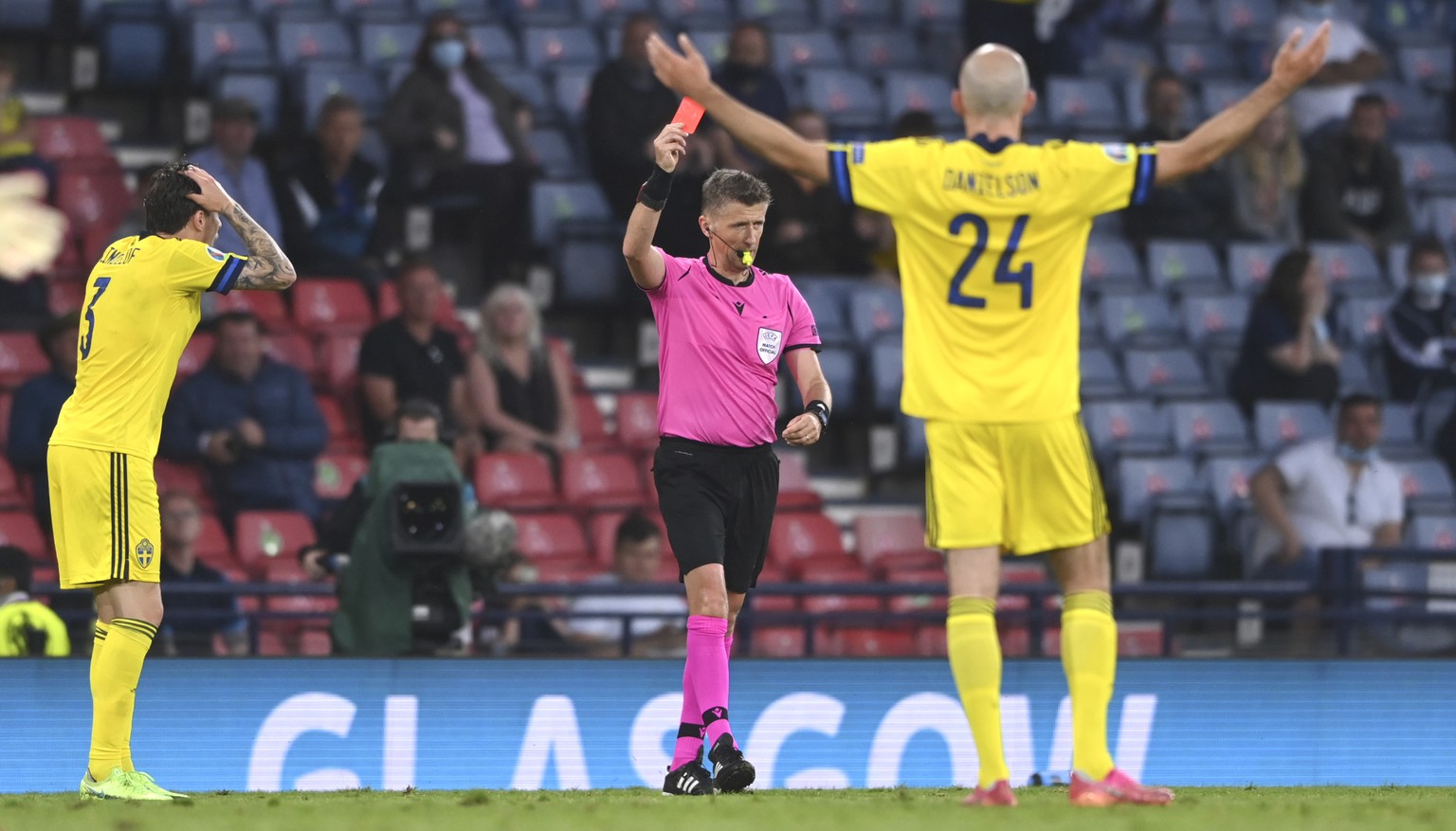A referee Daniele Orsato gives red card to Sweden&#039;s Marcus Danielson, right, during the Euro 2020 soccer championship round of 16 match between Sweden and Ukraine at the Hampden Park Stadium in G ...
