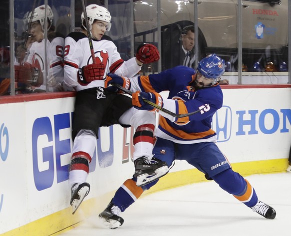 New York Islanders' Nick Leddy (2) checks New Jersey Devils' Nico Hischier (13) during the first period of an NHL hockey game Tuesday, Jan. 16, 2018, in New York. (AP Photo/Frank Franklin II ...