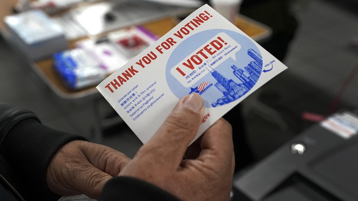 A voter receives his I Voted card after casting his ballot at the Su Nueva Lavanderia near Chicago's Midway Airport Tuesday, Nov. 8, 2022, in Chicago. (AP Photo/Charles Rex Arbogast)