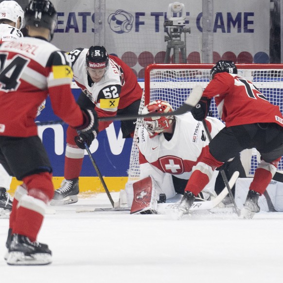 Austria&#039;s Paul Huber, center, scores to 2-0 against Switzerland&#039;s Goalkeeper Reto Berra during the Ice Hockey World Championship group A preliminary round match between Switzerland and Austr ...