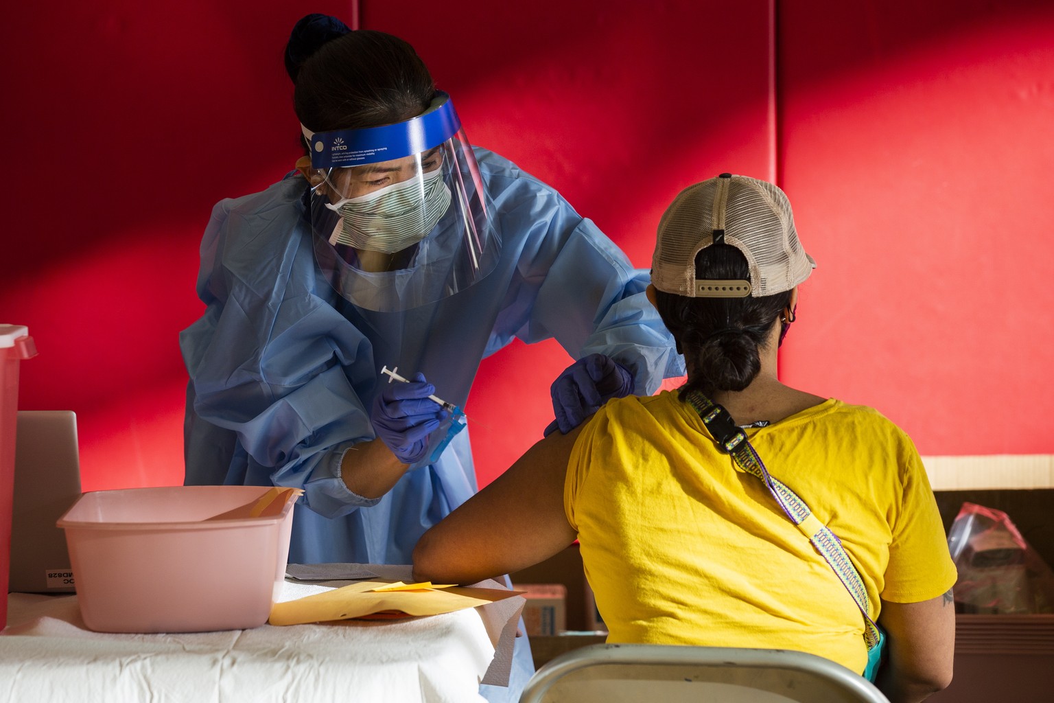 epa08939935 Nurse Irene Musni gives the Moderna vaccine against COVID 19 to a patient at the Corona High School amid the coronavirus pandemic in Corona, Riverside County, East of Los Angeles, Californ ...