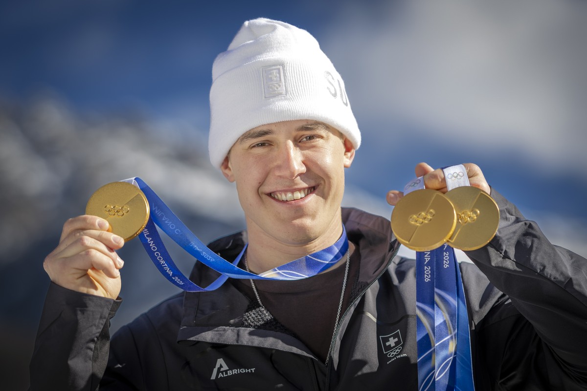 Gold medalist Franjo von Allmen of Switzerland poses for photographers with his three gold medals during a photocall outside the Swiss team hotel at the 2026 Olympic Winter Games at the Stelvio Ski ce ...