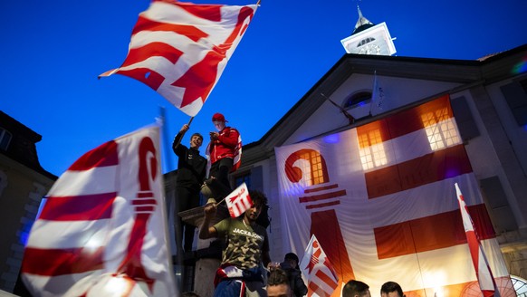 Les pro-jurassiens celebrent le oui devant l&#039; Hotel de Ville ou a ete dresse un drapeau du canton du Jura apres l&#039;annonce du resultat du vote ce dimanche 28 mars 2021 a Moutier. Les citoyens ...
