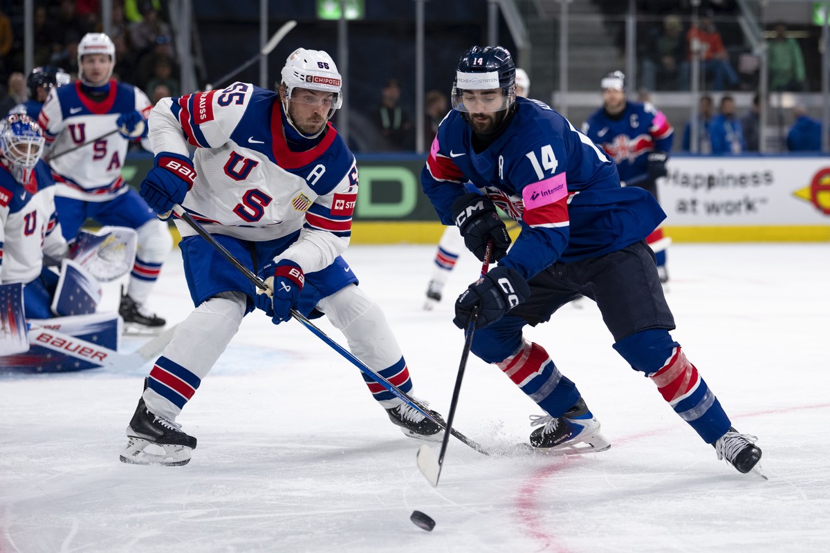 USA's Ryan Lindgren, left, fights for the puck against Great Britain's Liam Kirk, right, during the 2026 IIHF Men's Ice Hockey World Championship preliminary round group A game between  ...