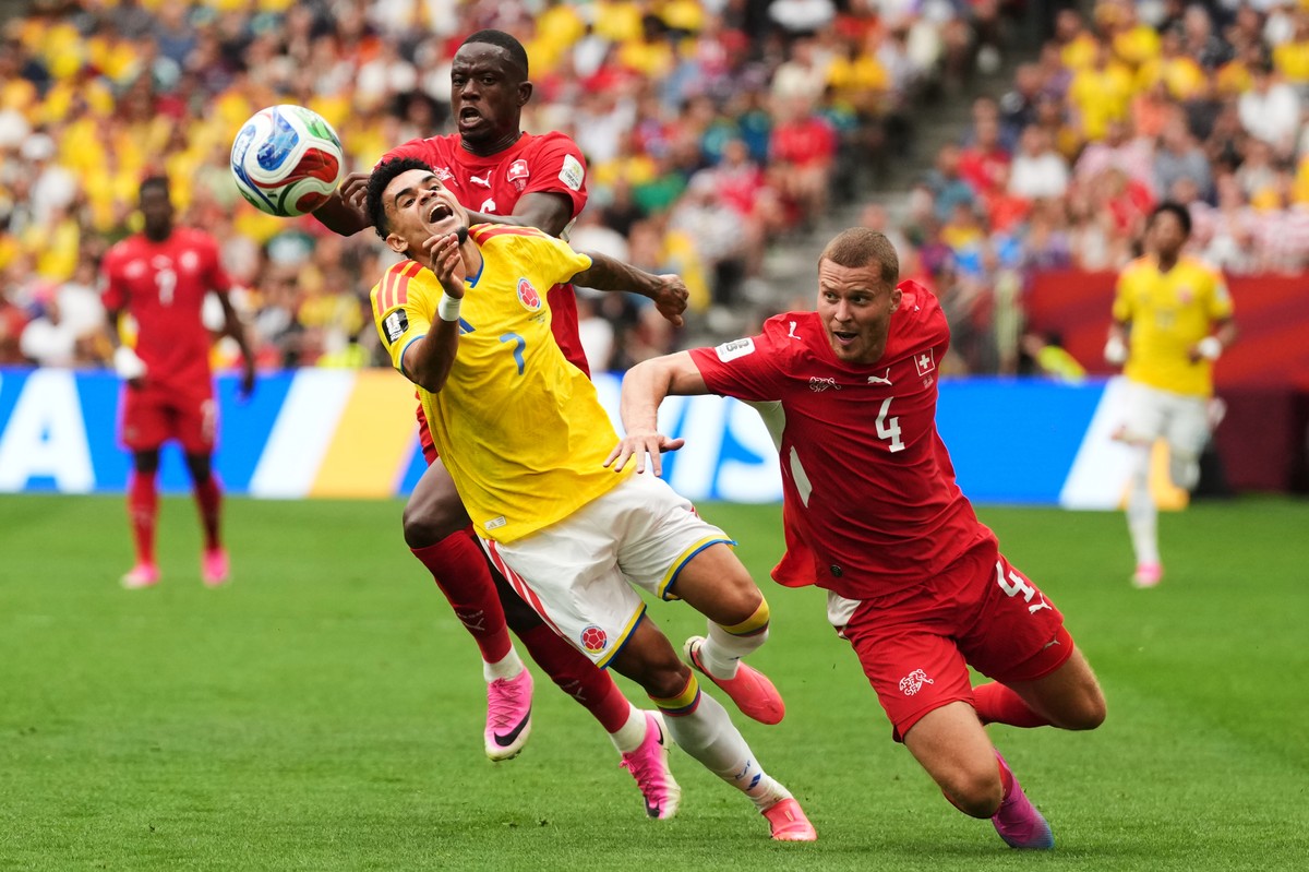 Colombia's Luis Diaz, center, fights for the ball against Switzerland's Denis Zakaria, rear, and Nico Elvedi, right, during the World Cup round of 16 soccer match between Switzerland and Col ...