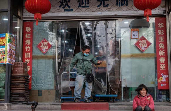 epa10400858 A man exits a grocery shop in Shanghai, China, 11 January 2023 (issued on 12 January 2023). China?s annual inflation rate rose to 1.8 percent in December 2022 over the previous month. In N ...