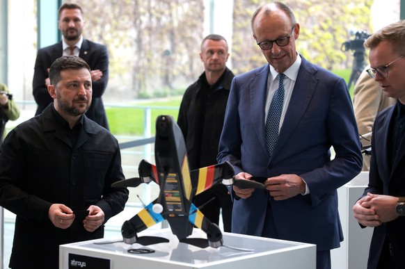 epa12888588 German Chancellor Friedrich Merz (C) and Ukrainian President Volodymyr Zelensky (L) watch a presentation of military equipment and drones made in German-Ukrainian cooperation at the Chance ...