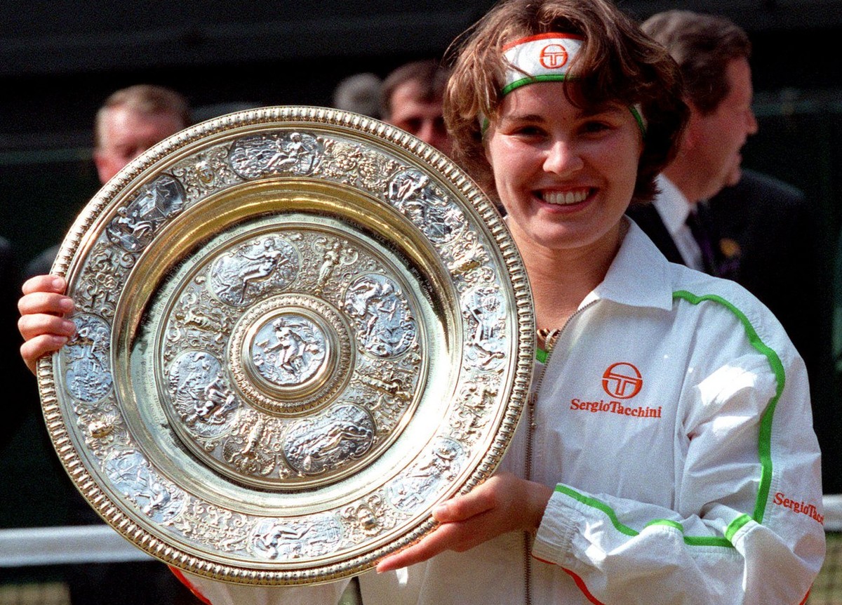 Martina Hingis holds her trophy, after defeating Jana Novotna in the Women's Singles final on the Centre Court at Wimbledon, July 5, 1997. Hingis won the final 2-6, 6-3, 6-3, to become the younge ...