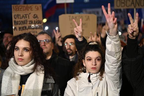 Protesters strike the v sign as thousands gather to oppose the policies of Slovakia&#039;s Prime Minister Robert Fico in Bratislava, Slovakia, Friday, Jan. 24, 2025. (AP Photo/Denes Erdos)