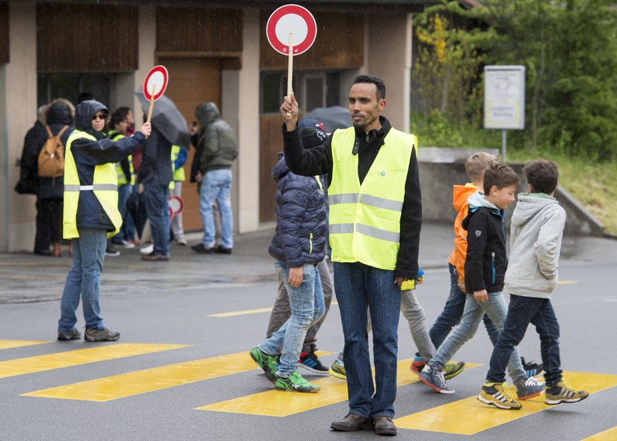 JAHRESRUECKBLICK 2016 - APRIL - Ein Asylbewerber, rechts, und eine Schweizer Begleiterin, links, bei der Verrichtung des Schulpatrouilleurendienstes am Dienstag, 26. April 2016 in Boesingen. Da in Boe ...