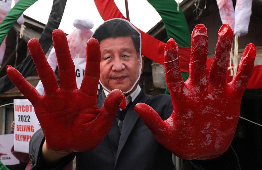 epa08984326 Tibetans living in-exile and activists belonging to different NGOs hold placards during a protest against alleged Chinese atrocities and to boycott the 2022 Beijing Winter Olympics, at McL ...