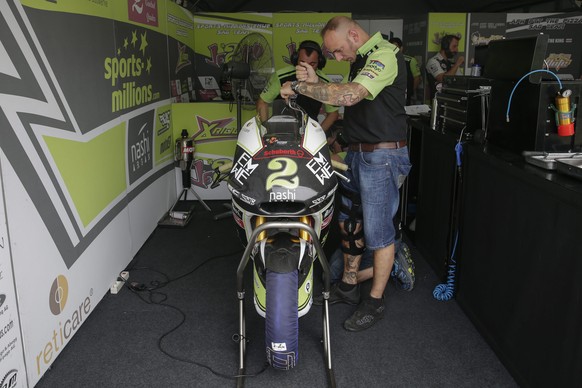 epa04992383 Team members of Swiss Moto2 rider Jesko Raffin prepare his motorbike inside the pit during the 2015 Malaysian Motorcycling Grand Prix in Sepang International Circuit near Kuala Lumpur, Mal ...