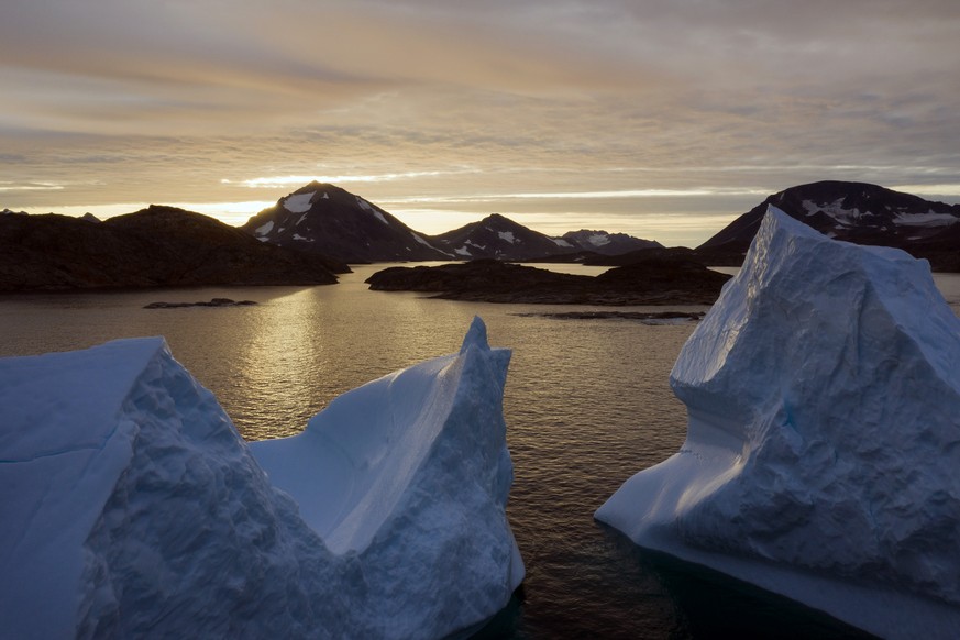 An aerial view of large Icebergs floating as the sun rises near Kulusuk, Greenland, early Friday, Aug. 16, 2019. Greenland has been melting faster in the last decade and this summer, it has seen two o ...
