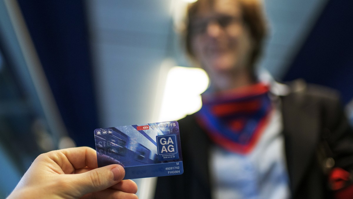 SBB-Zugbegleiterin Priska Portmann bei der Billetkontrolle im ICN von Zuerich nach Genf, aufgenommen am 29. Mai 2013. Ein Fahrgast zeigt sein GA (Generalabonnement). (KEYSTONE/Christian Beutler)