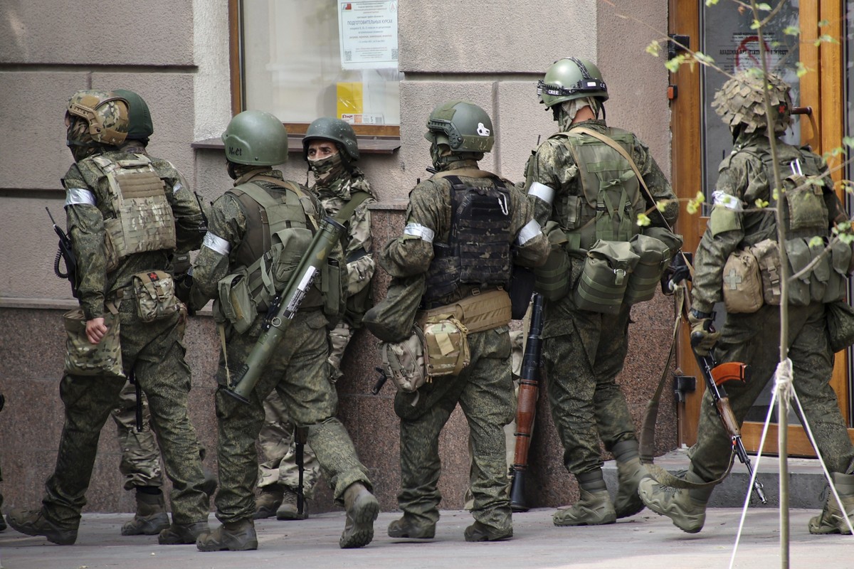 Russian servicemen walk along a street in Rostov-on-Don, Russia, Saturday, June 24, 2023. Russia's security services have responded to mercenary chief Yevgeny Prigozhin's declaration of an a ...