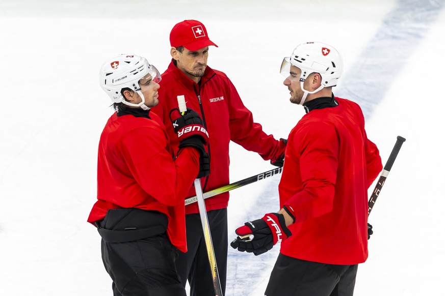 Patrick Fischer, head coach of Switzerland national ice hockey team, speaks with Switzerland's Kevin Fiala, left, and Switzerland's Timo Meier, right, during a training session of team Switz ...
