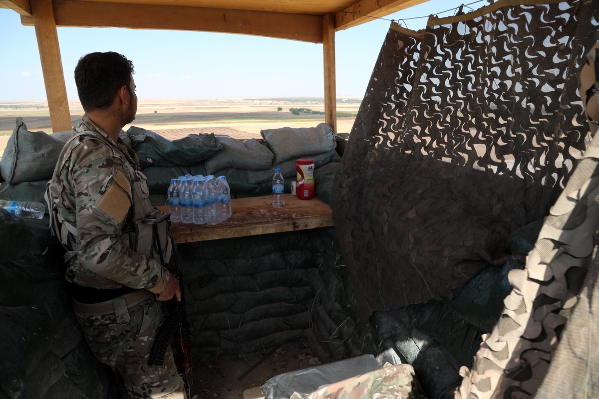 epa07907563 A fighter of the Self-Defense Forces (SDF) keeps watch towards the Turkish border after fighters moved to front lines near the border with Turkey, at Tal Arqam village, Ras al-Ein, north S ...