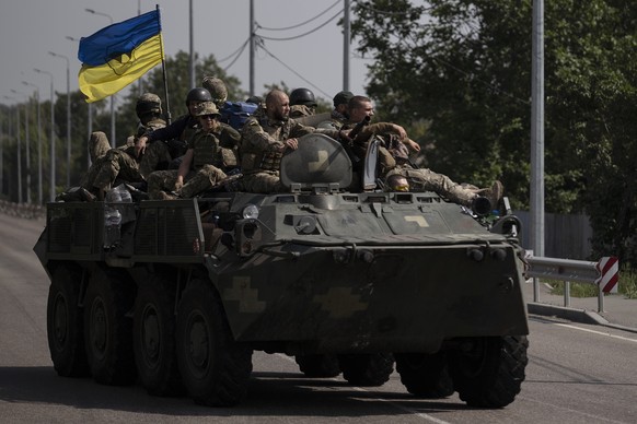 FILE - Ukrainian servicemen ride atop of an armored vehicle on a road in Donetsk region, eastern Ukraine, Sunday, Aug. 28, 2022. As the war slogs on, a growing flow of Western weapons over the summer  ...