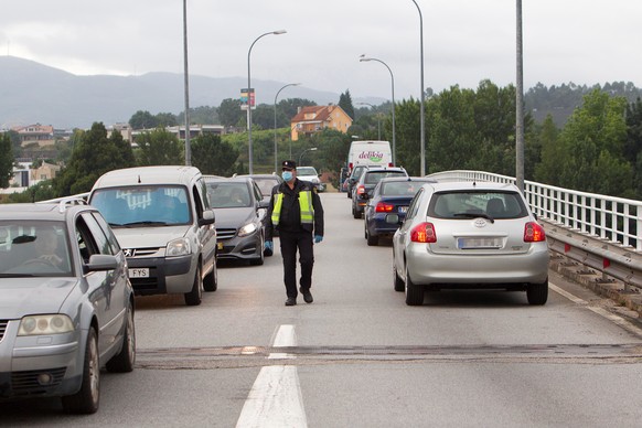 epa08485965 National policemen watch the border road that has been reopened to go to Portugal at the village of Salvaterra Do Mino, Pontevedra, Spain, 15 June 2020 during the phase 3 of the desescalat ...