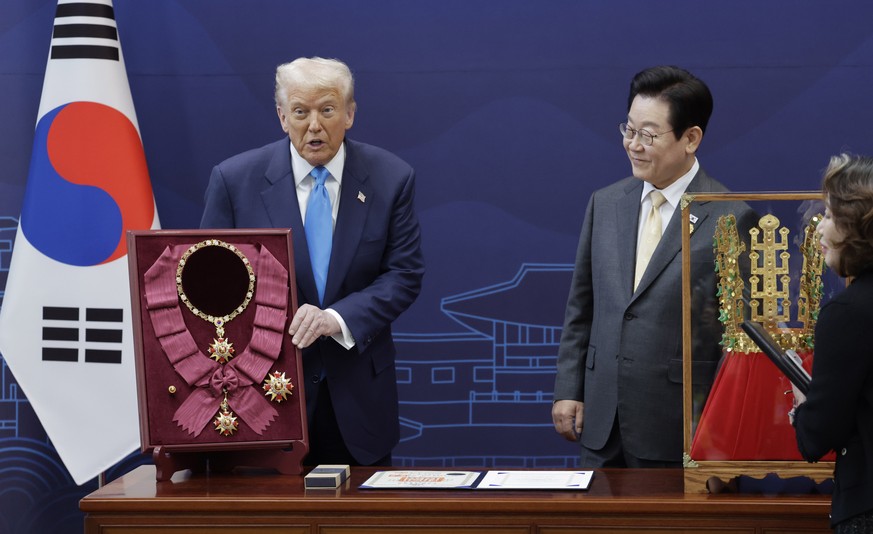 epa12489355 South Korean President Lee Jae Myung (R) speaks to US President Donald Trump (L) after conferring the state-awarded Grand Mugunghwa Medal, South Korea's highest order of civil merit,  ...
