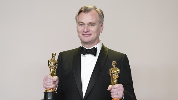 Christopher Nolan poses in the press room with the awards for best director and best picture for "Oppenheimer" at the Oscars on Sunday, March 10, 2024, at the Dolby Theatre in Los Angeles. ( ...
