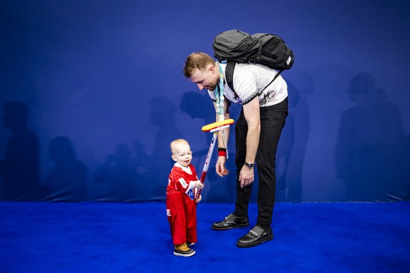 Yannick Schwaller of Switzerland plays with his son River during the curling mixed doubles round robin game between Switzerland and Czech Republic at the 2026 Olympic Winter Games in the Cortina Curli ...