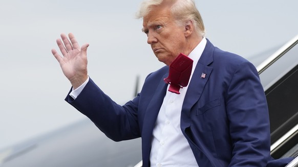 FILE - Former President Donald Trump waves as he steps off his plane at Ronald Reagan Washington National Airport, Aug. 3, 2023, in Arlington, Va. A slim majority of Americans approve of the U.S. Just ...