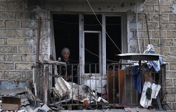 epaselect epa08721179 A woman looks out the window of apartment house after shelling by Azerbaijani artillery, Stepanakert, Nagorno-Karabakh, 04 October 2020. AArmed clashes erupted on 27 September 20 ...