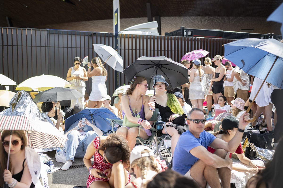 Fans, also known as 'Swifties', wait to attend the concert of US singer and songwriter Taylor Swift as part of her 'The Eras Tour' in front of the Letzigrund Stadium in Zurich, Swi ...