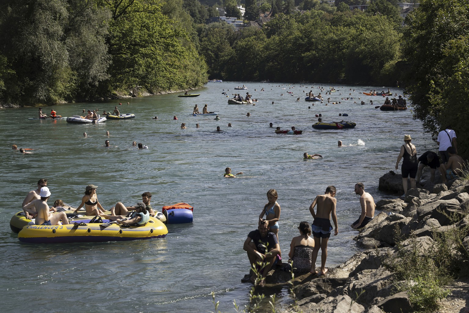People swim and sail on inflatable boats, on the Aare River, during the sunny and warm weather, in Bern, Switzerland, Sunday, Aug. 20, 2023. Many parts of Switzerland have been experiencing a period o ...
