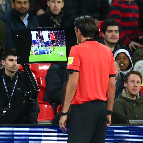 epa06633193 Referee Deniz Aytekin of Germany looking at the VAR during the International friendly match between England and Italy at the Wembley Stadium in London, Britain, 27 March 2018. EPA/KIERAN G ...