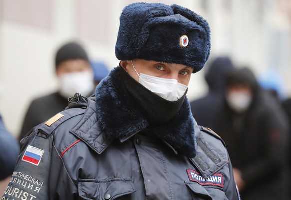 epa08340673 A Russian police officer wearing a protective face mask stands outside a migration control centre amid the ongoing coronavirus COVID-19 pandemic in St. Petersburg, Russia, 03 April 2020. R ...