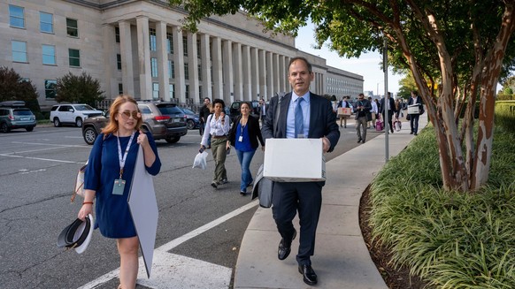 Members of the Pentagon press corp carry their belongings out of the Pentagon after turning in their press credentials, Wednesday, Oct. 15, 2025 in Washington. (AP Photo/Kevin Wolf)