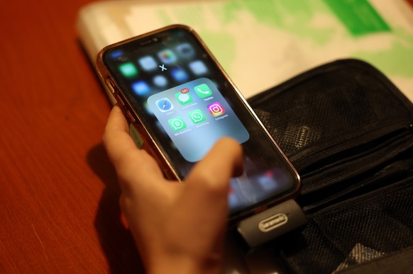 epa11796282 A woman uses her smartphone while sitting in a cafe in Tehran, Iran, 28 December 2024. The Iranian government on 27 December 2024 unblocked Whatsapp and Google Play after two years, while  ...