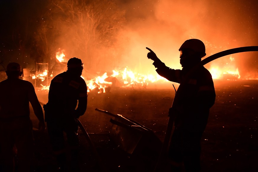 Fire burns a house in Adames area, in northern Athens, Greece, Tuesday, Aug. 3, 2021.Thousands of people fled their homes north of Athens on Tuesday as a wildfire broke out of the forest and reached r ...